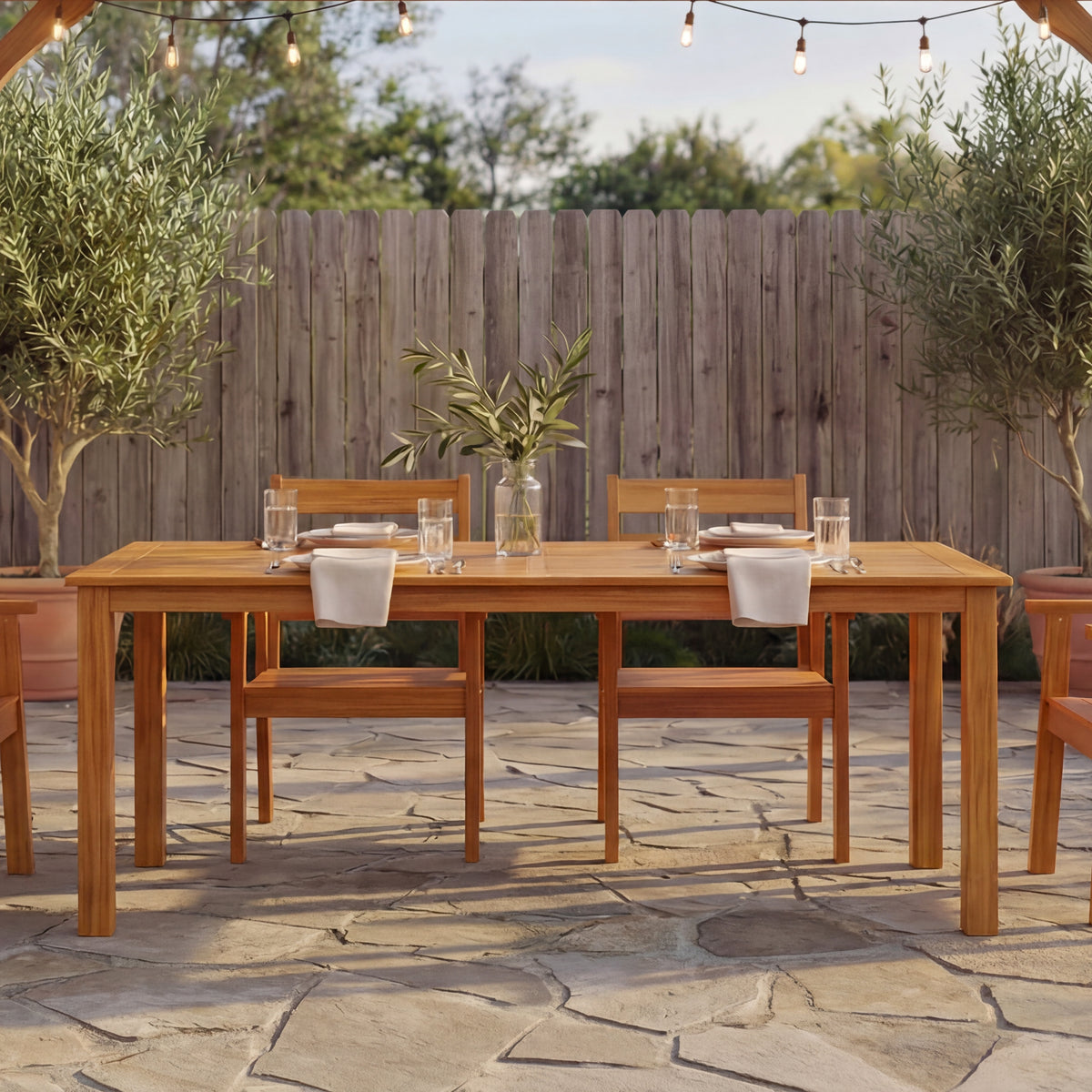 Wooden outdoor dining set with table and chairs on a stone patio
