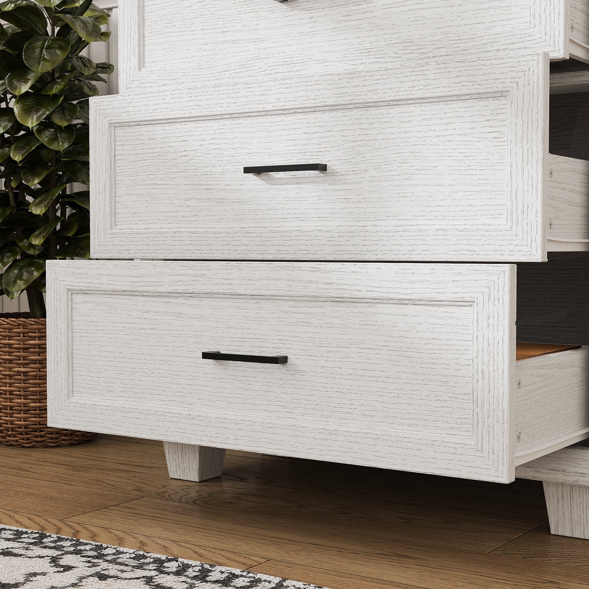 White 3-drawer nightstand with raised panel fronts and black handles