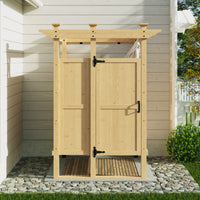 Wooden outdoor shower enclosure with a roof and doors, set against a house exterior