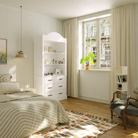 Modern bedroom with white furniture, wooden floor, and large window.