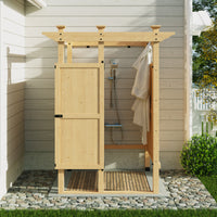 Wooden outdoor shower enclosure with a roof and doors, set against a house exterior