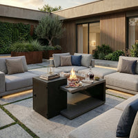 Modern outdoor patio with gray sofa, fire pit table, and decorative items.