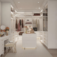 Modern walk-in closet with white furniture, clothing, and accessories.