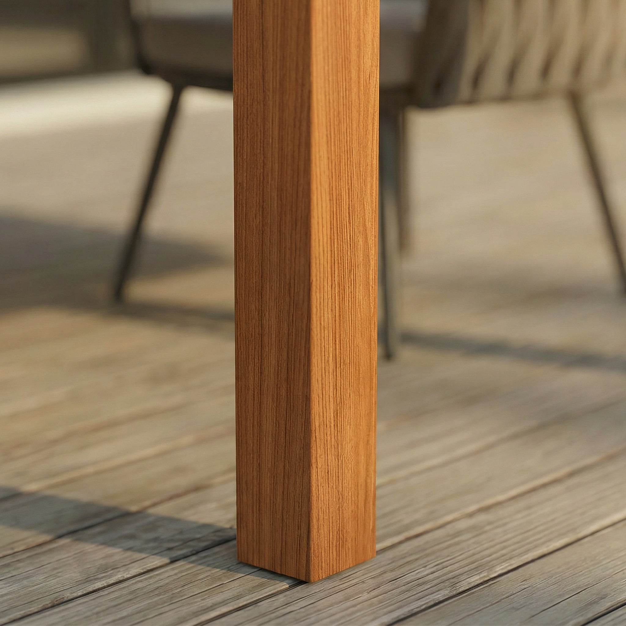 Close-up of a wooden chair leg on a wooden deck with blurred chairs in the background