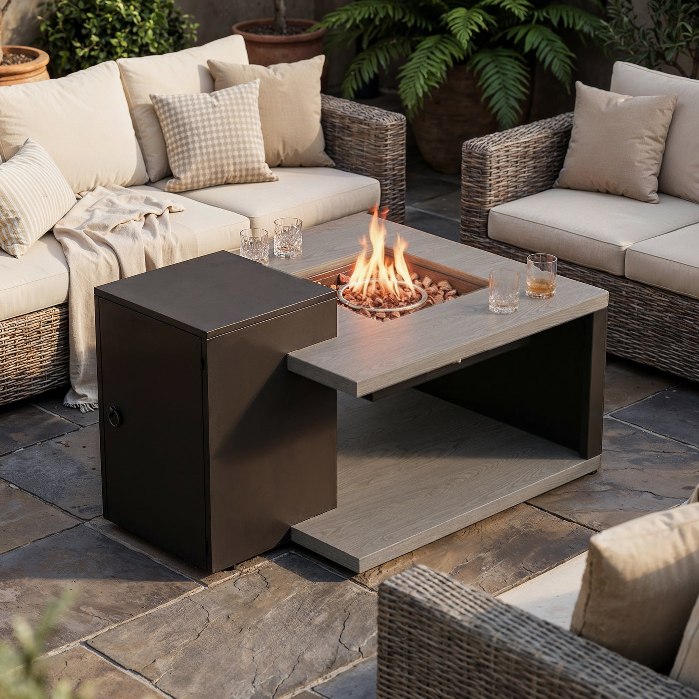 Outdoor patio setting with fire pit table and wicker chairs.