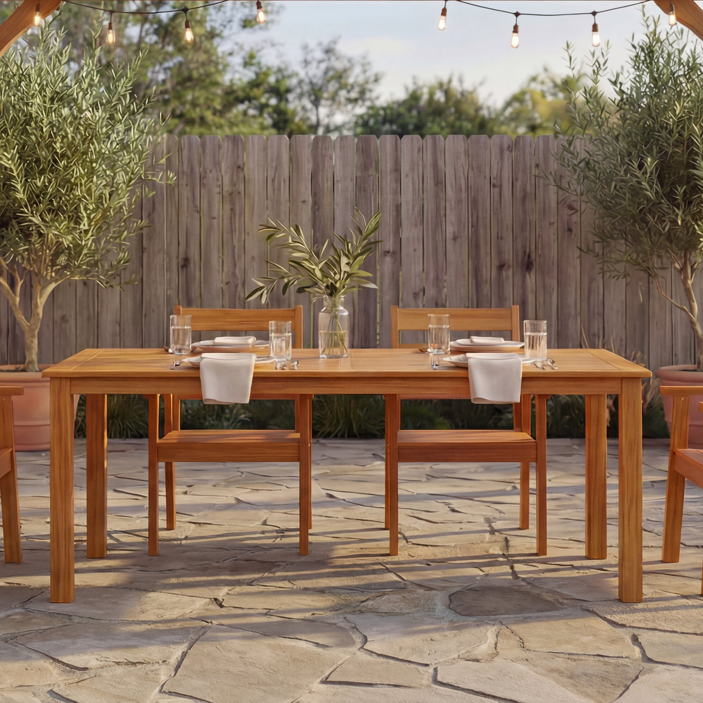 Wooden outdoor dining set with table and chairs on a stone patio