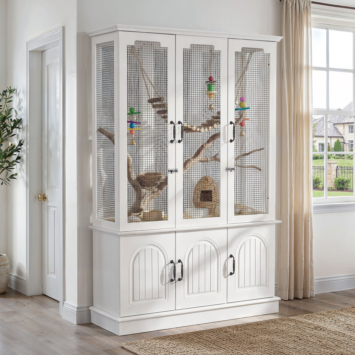 White pet cage with glass doors in a room with a window and door.