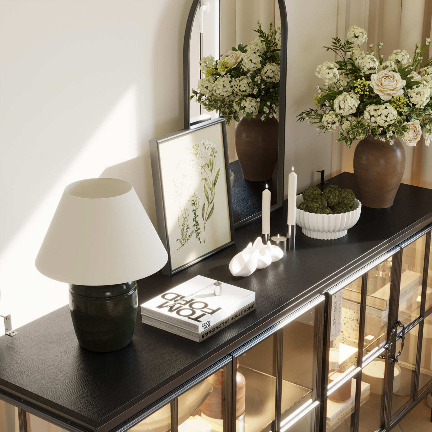 Decorative console table with flowers, lamp, and books in a home setting