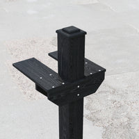 Black wooden post with steps on a gray concrete surface