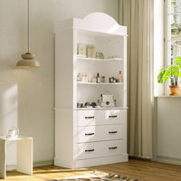 White tall cabinet with shelves and drawers in a room with a window and plant.