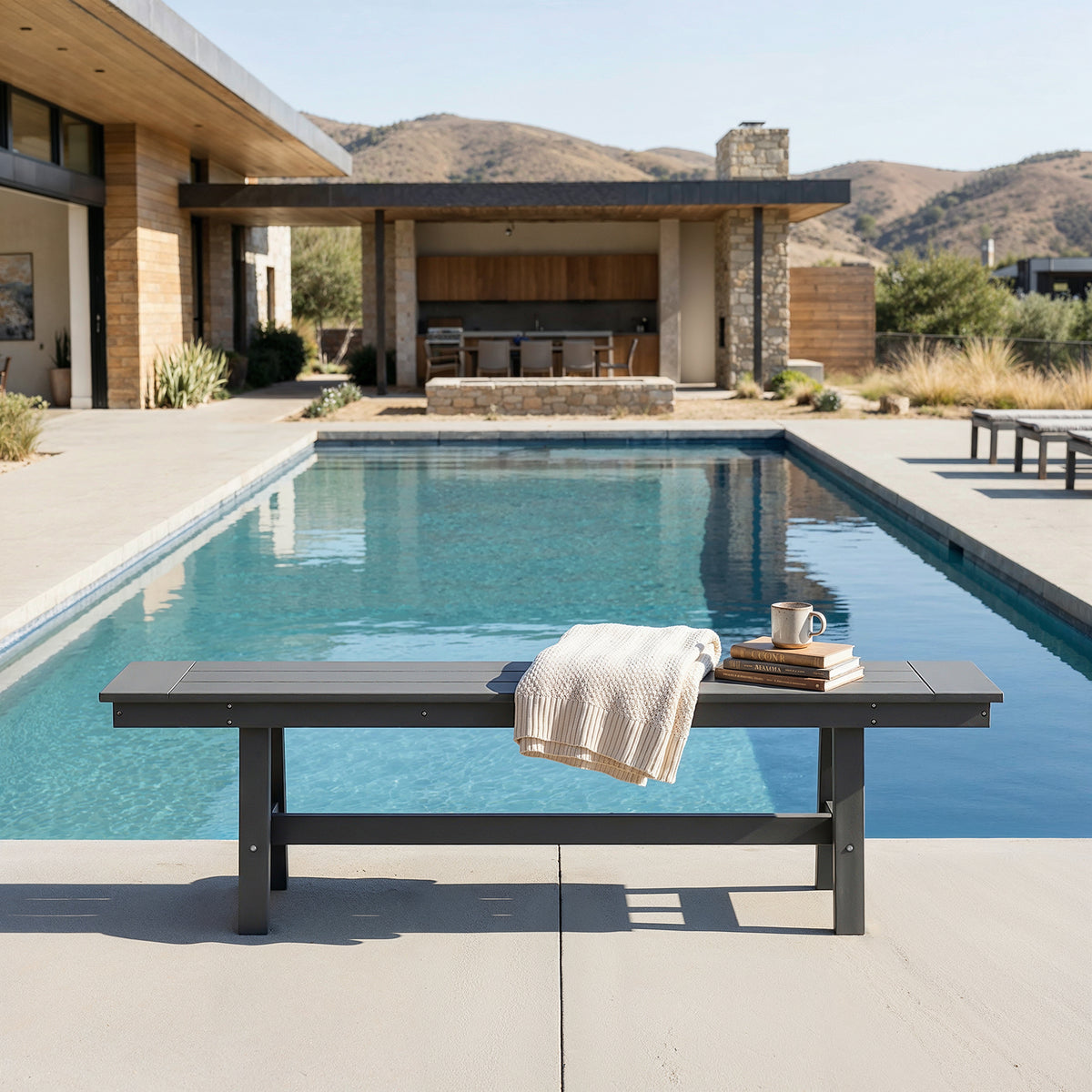 Outdoor setting with a pool, bench, and mountainous landscape