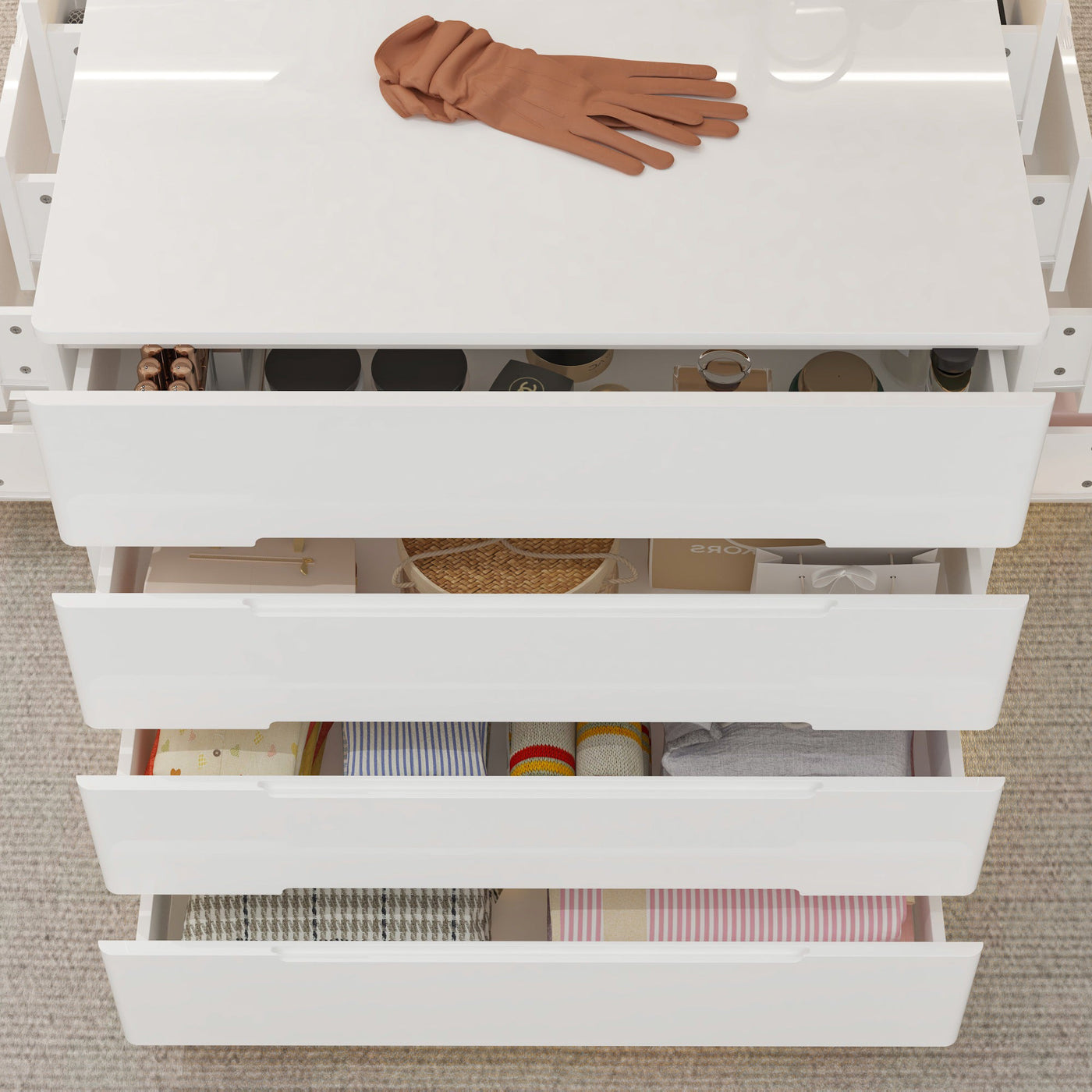 White drawer unit with various items including a brown glove on a light wooden floor.