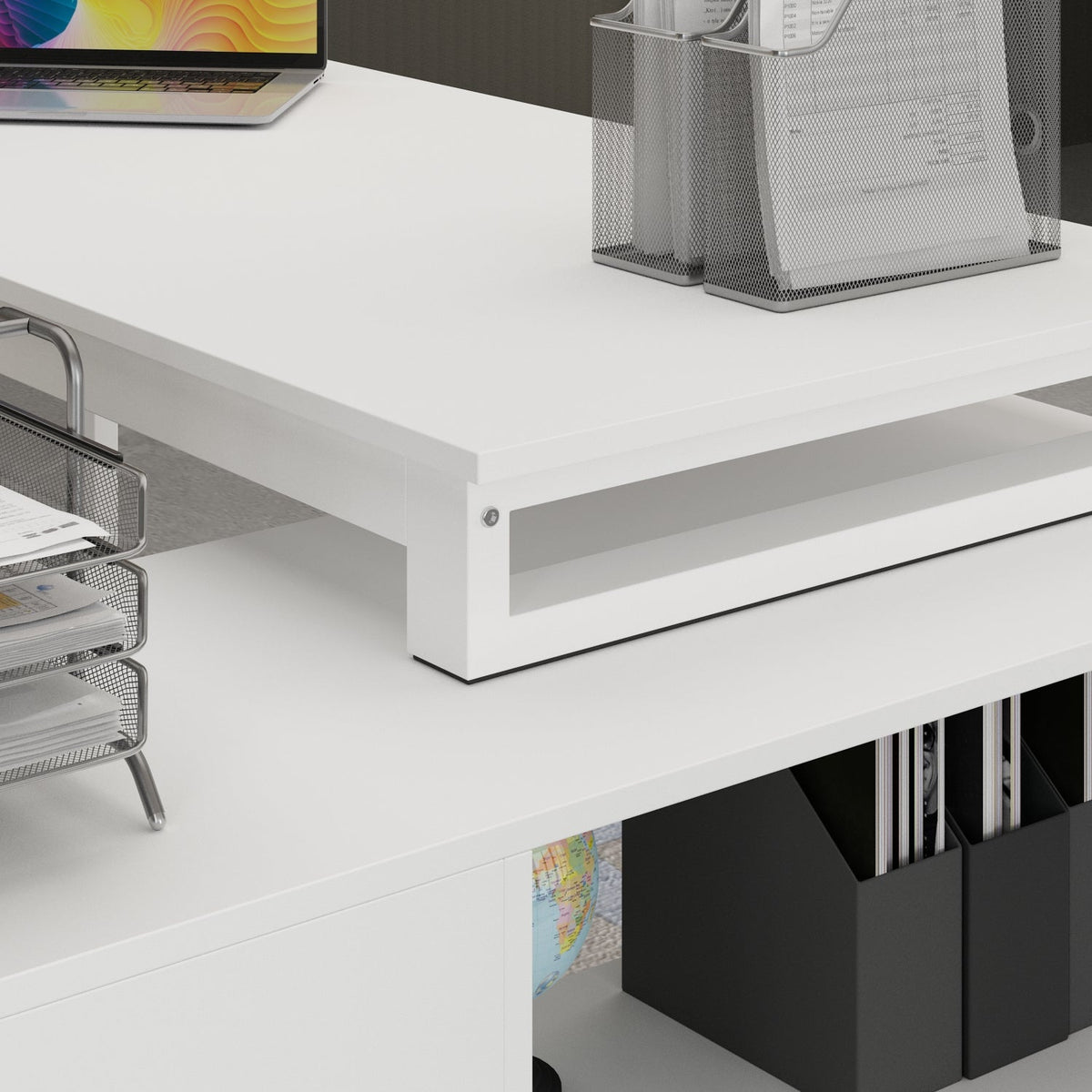 White office desk with a laptop, files, and a magazine holder.