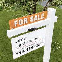 Real estate sign with contact information on a grassy lawn.