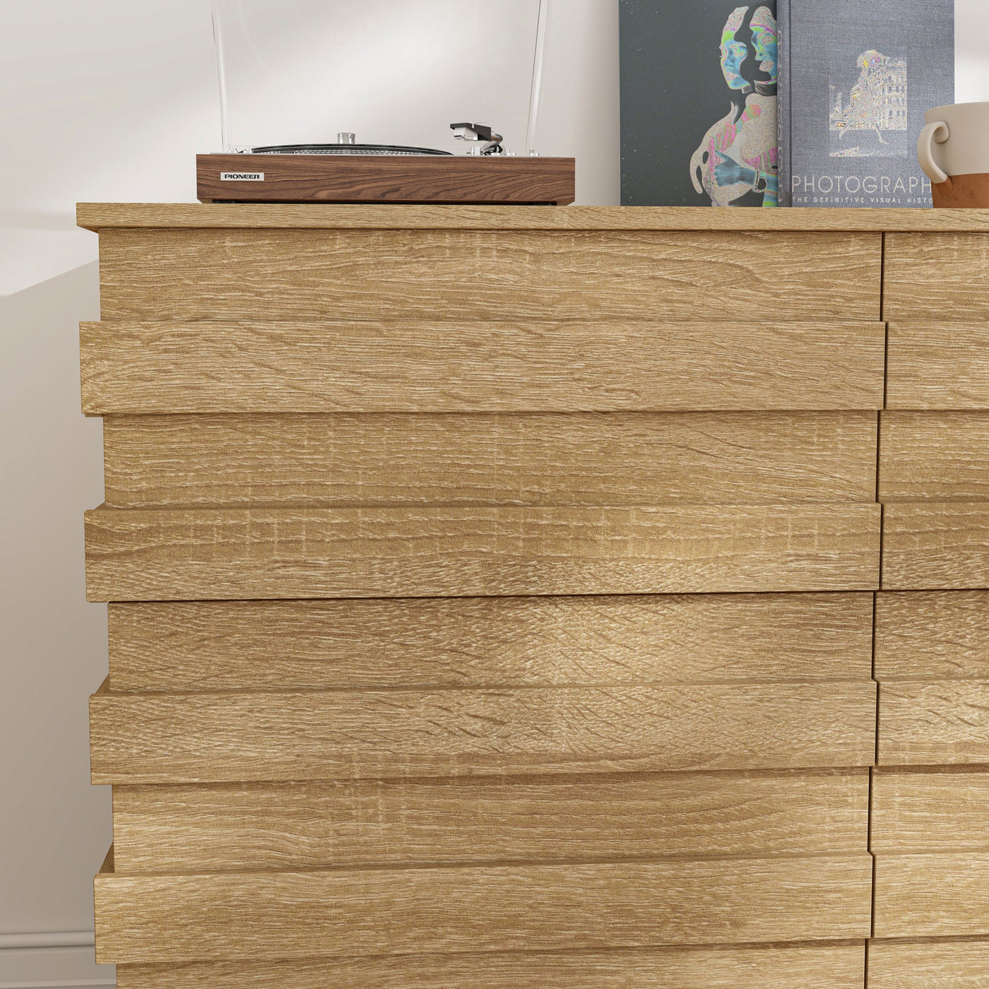 Wooden dresser with a record player on top against a white wall