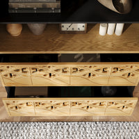 Wooden dresser with decorative carvings on a wooden floor.