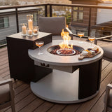 An outdoor fire pit table with a crackling fire, drinks, and snacks, set up on the balcony.