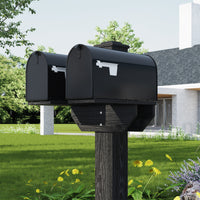 Black mailbox on a wooden post in a garden with a house in the background