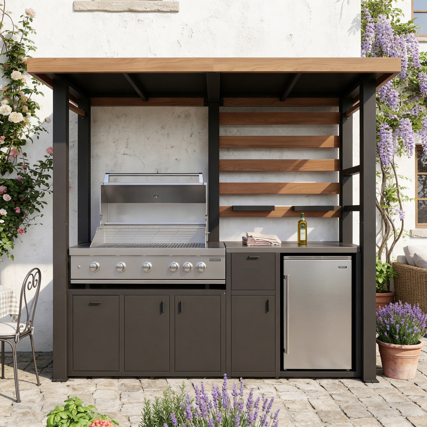 Outdoor kitchen with grill, cabinets, and refrigerator against a white wall.