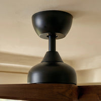 Black ceiling light fixture on a beige wall