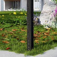 Garden scene with a wooden post, grass, flowers, and rocks