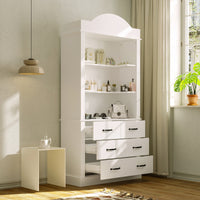 White tall cabinet with shelves and drawers in a room with a lamp and plant.