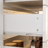 Close-up of a kitchen cabinet with a white drawer and metallic handles.