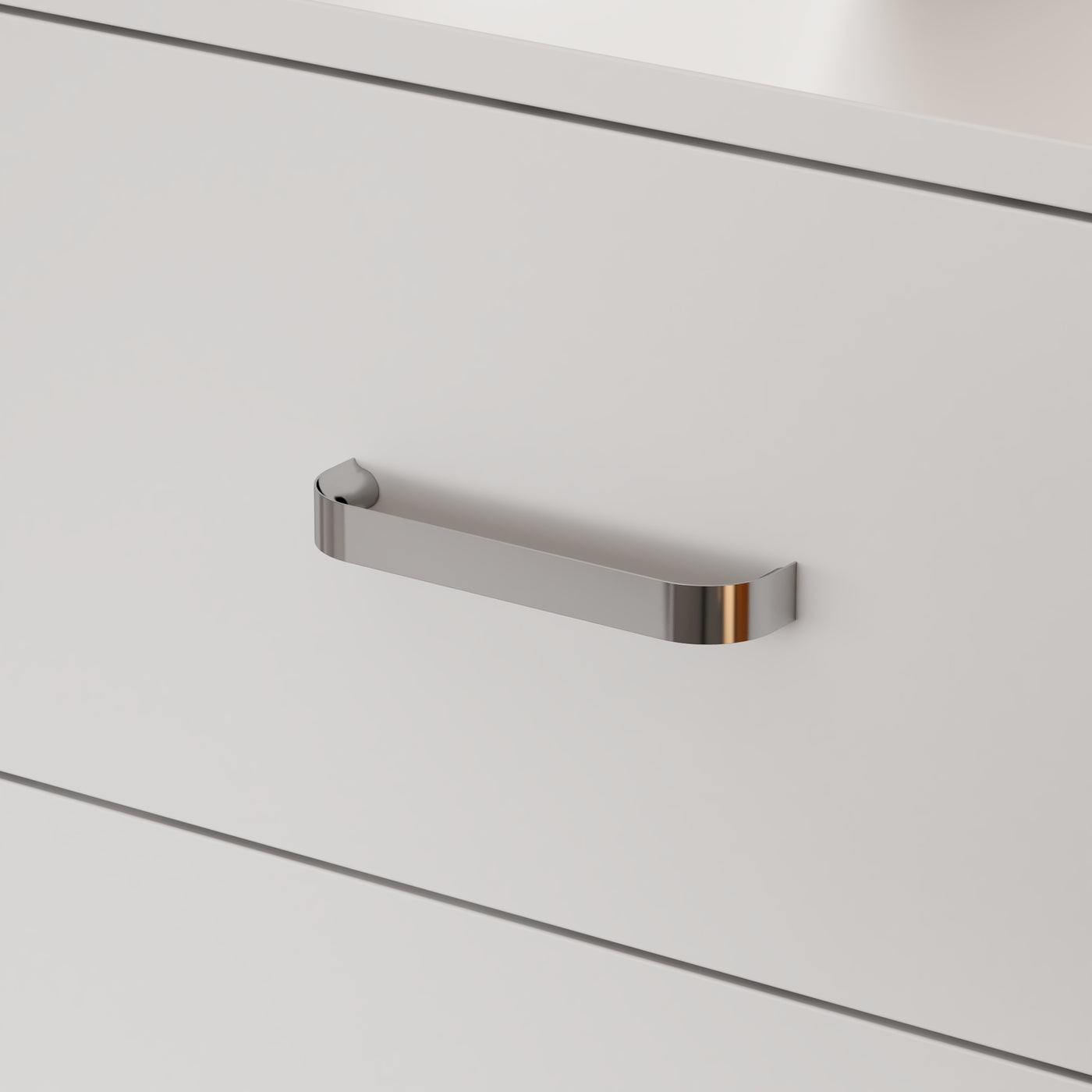 Close-up of a metallic handle on a white cabinet door
