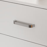 Close-up of a metallic handle on a white cabinet door
