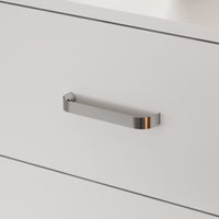 Close-up of a metallic handle on a white cabinet door