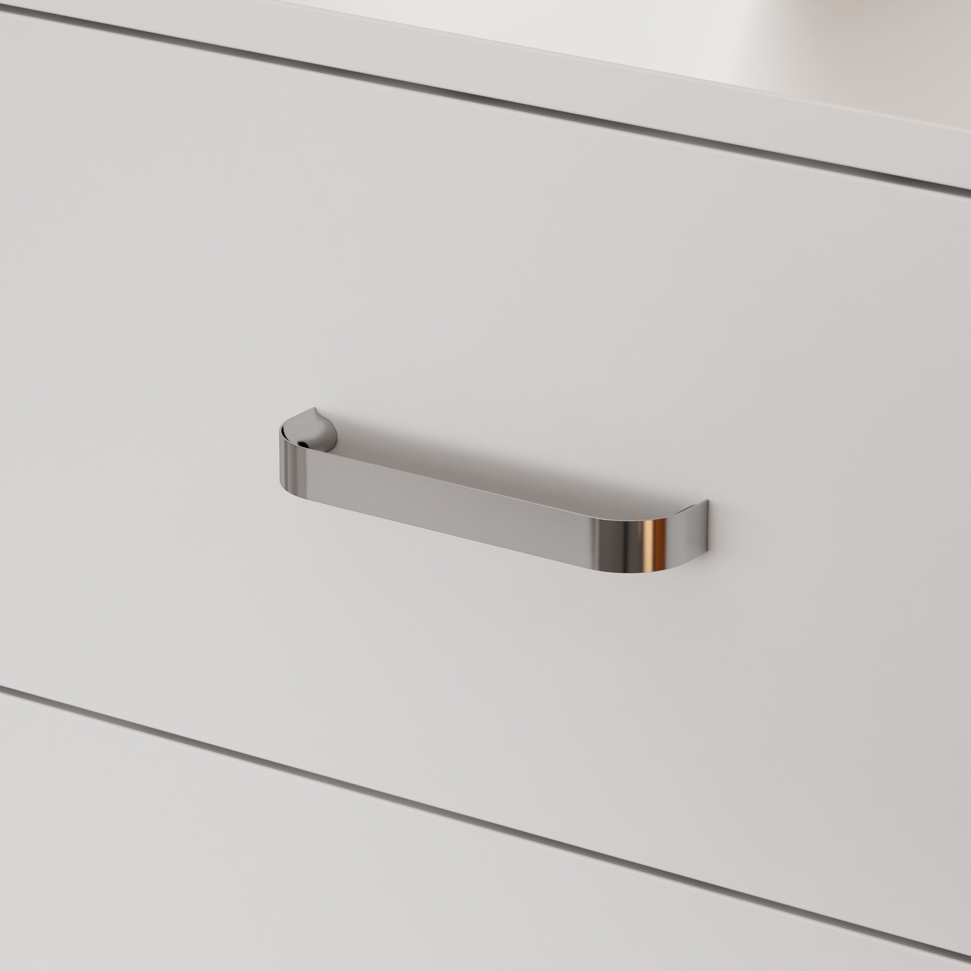 Close-up of a metallic handle on a white cabinet door