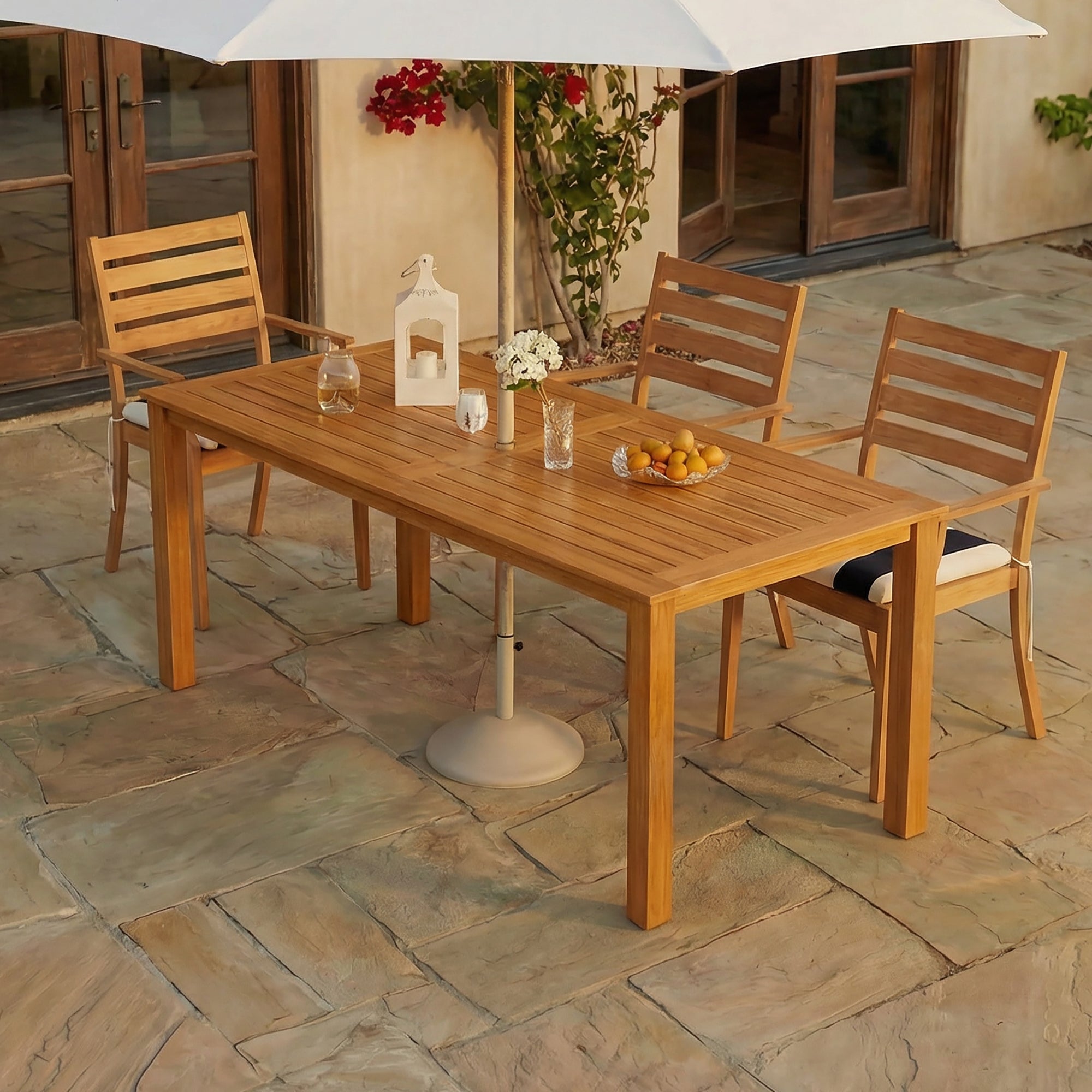 Wooden outdoor dining table with chairs on a stone patio