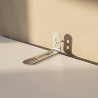 Metal bracket on a beige wall and white surface