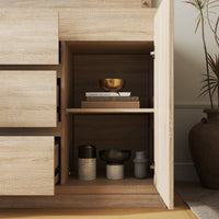 Wooden cabinet with open doors displaying decorative items in a room setting