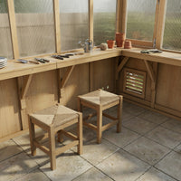 Wooden workbench with stools in a greenhouse setting