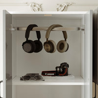 Two pairs of headphones hanging on a shelf with a camera and books below.