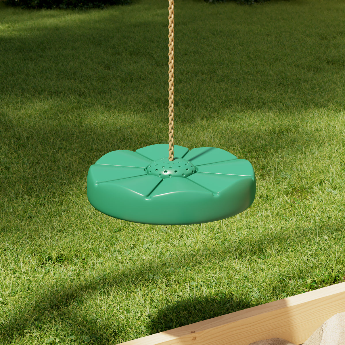 Green swing seat hanging on a chain against a grassy background