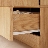 Wooden drawer with clothes inside, part of a wooden cabinet.