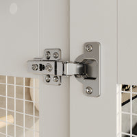 Close-up of a chrome door hinge on a white door with tiled wall background