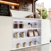 White reception desk with open display shelves and built-in LED lighting