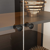 Modern interior design with a glass cabinet, black handles, and a decorative lamp.