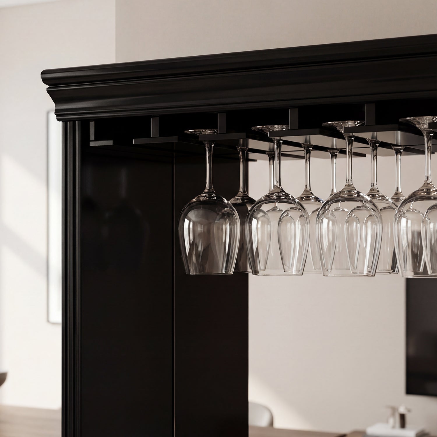 Black bar cabinet with wine glasses hanging from an overhead rack.