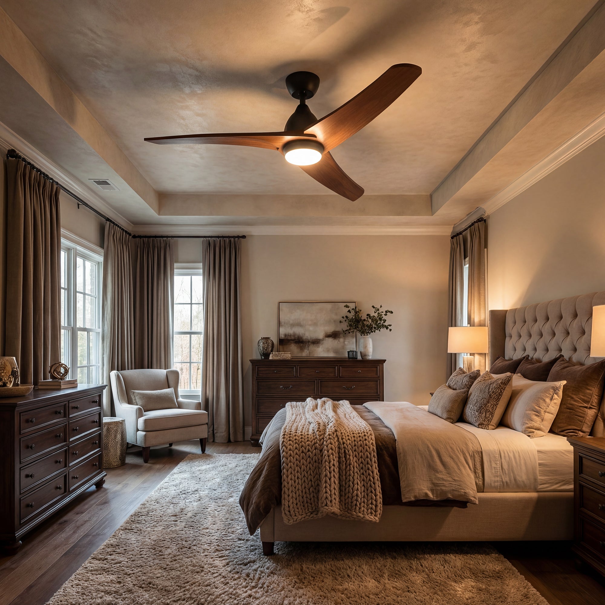 Luxurious bedroom with a bed, armchair, and ceiling fan.
