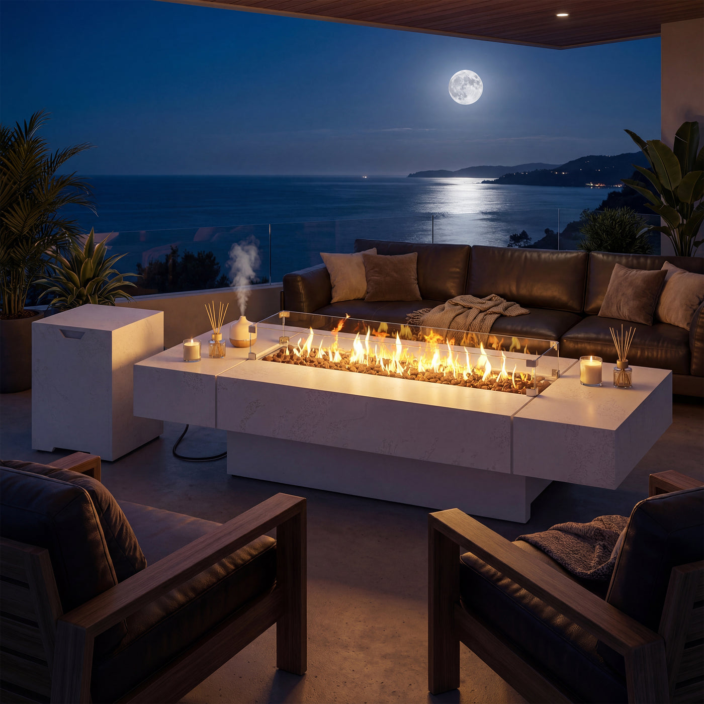 Outdoor patio with fire pit table, couches, and ocean view at night.